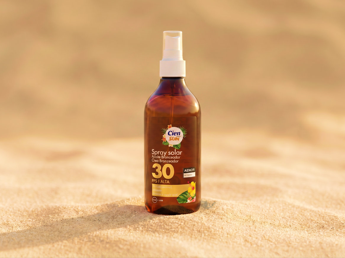 Spray solar com fator 30 em frasco castanho na areia.