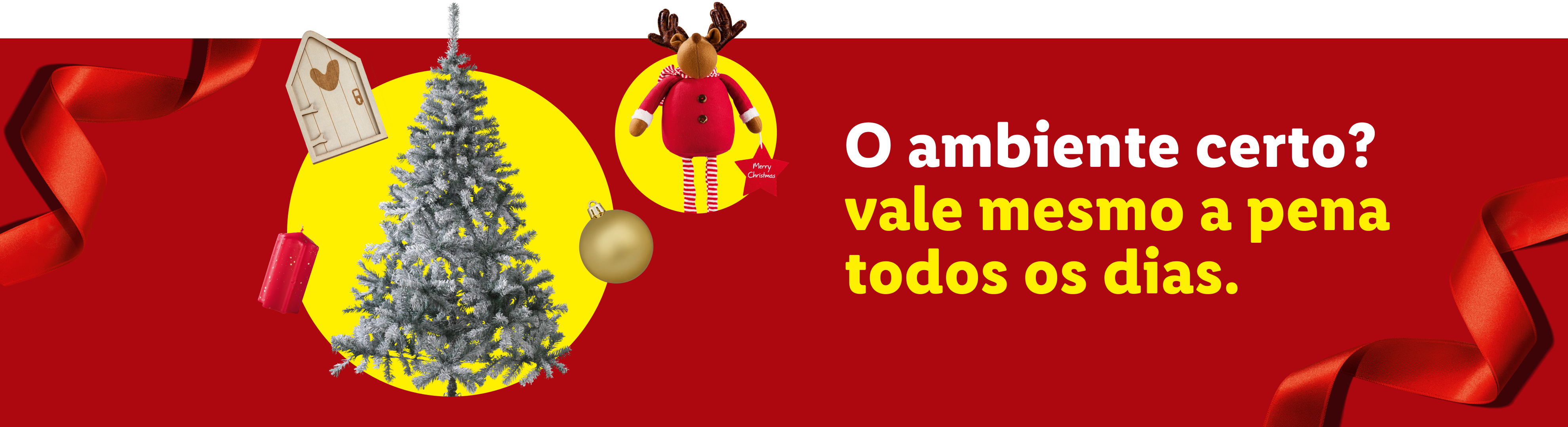 Decorações de Natal com árvore, rena e fita vermelha, com a frase 'O ambiente certo? vale mesmo a pena todos os dias.'