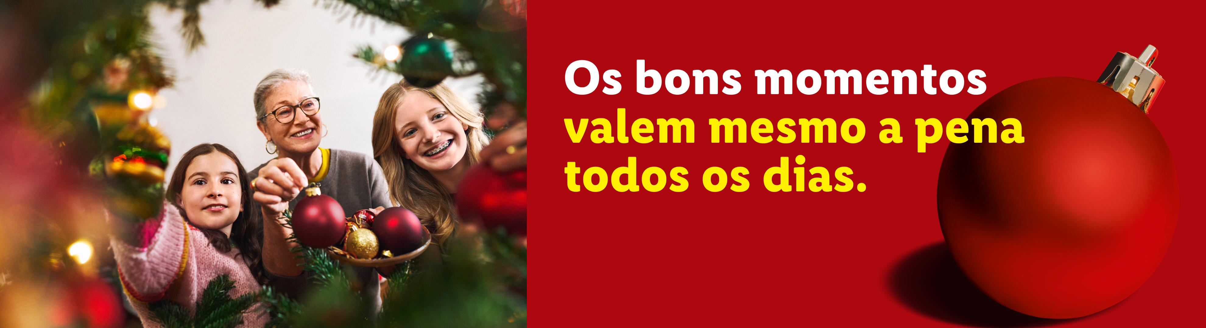 Família a decorar a árvore de Natal com enfeites vermelhos e dourados. Texto: Os bons momentos valem mesmo a pena todos os dias.