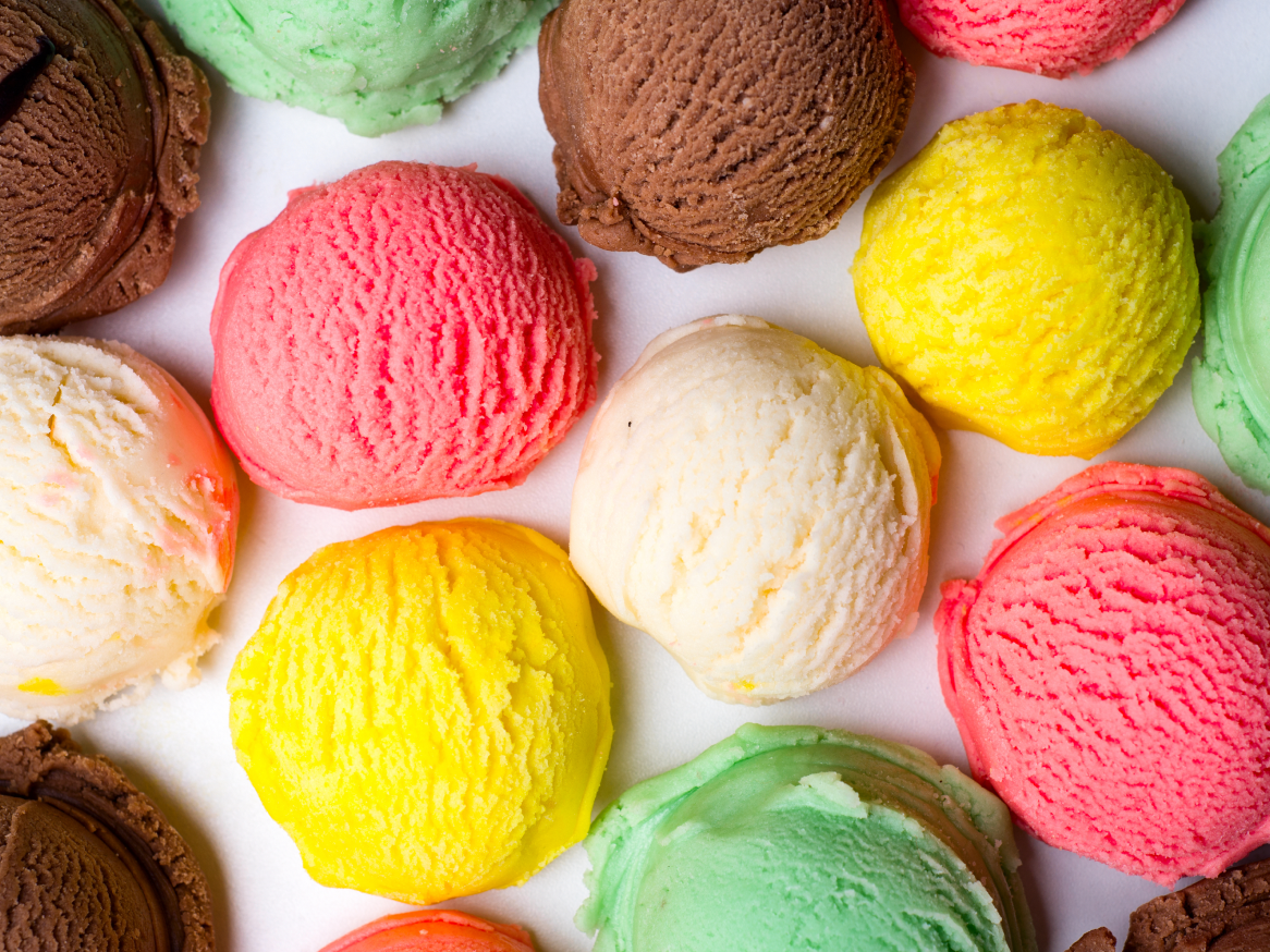 Bolas de gelado coloridas de vários sabores, incluindo morango, chocolate, baunilha, limão e menta.