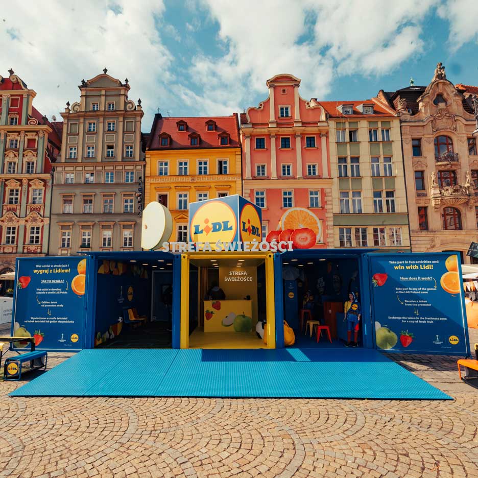 Uma instalação Lidl com tema de frutas e vegetais, com jogos e atividades, numa praça urbana.