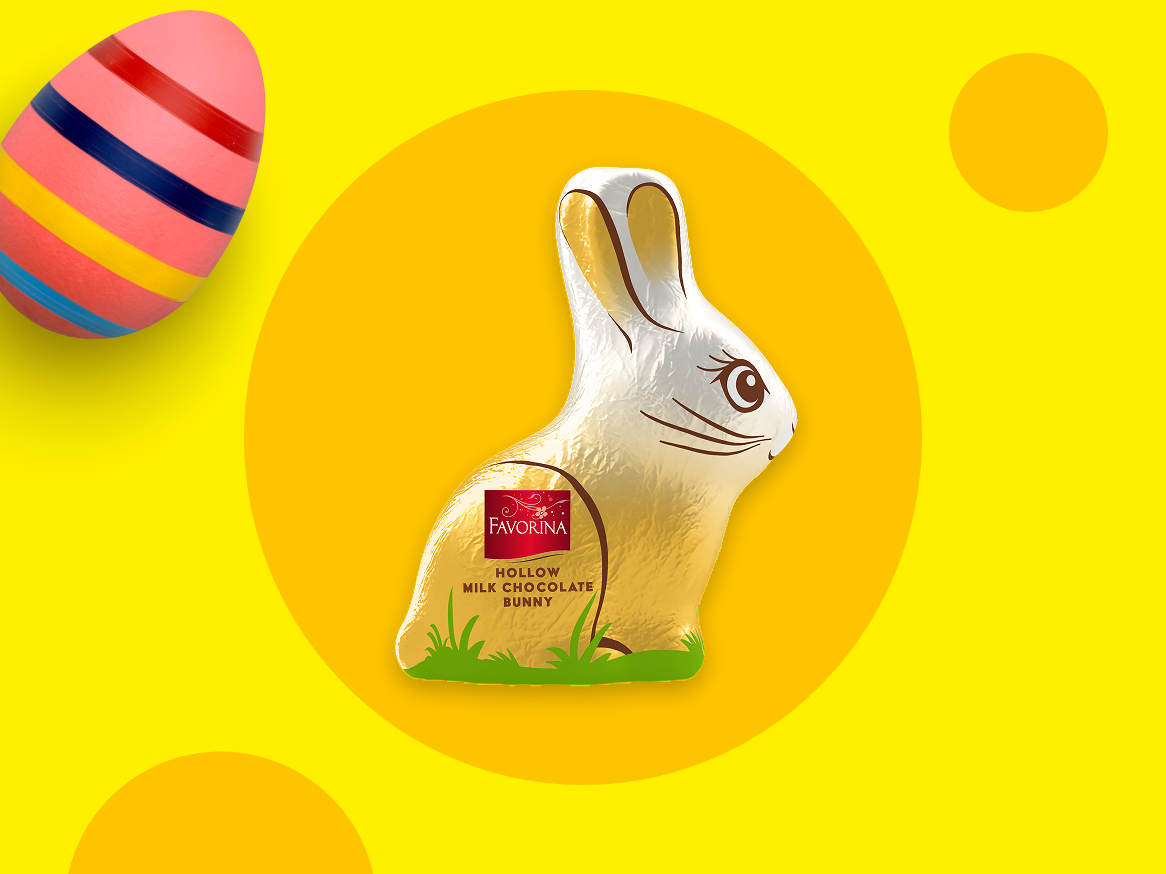 Coelho de chocolate oco e ovo de Páscoa decorado em fundo amarelo.