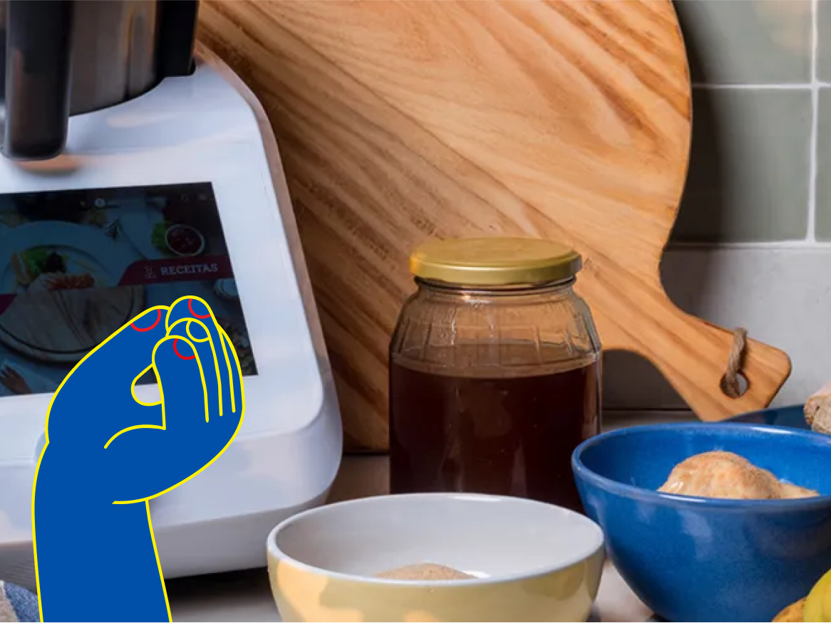 Um robô de cozinha com tela sensível ao toque, tábua de corte, mel e tigelas.