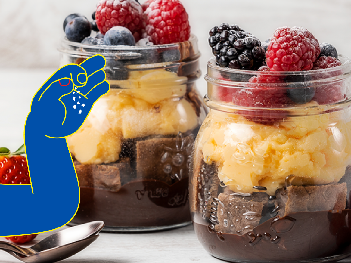 Dois frascos de vidro contêm sobremesas de brownie, sorvete e frutas vermelhas.