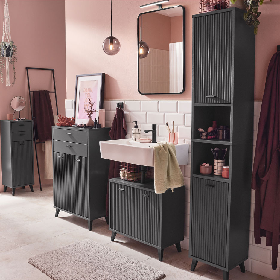 Banheiro moderno com móveis cinza escuro e detalhes rosa.