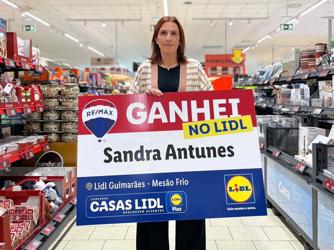 Mulher segura um cartaz 'GANHEI NO LIDL' com o nome Sandra Antunes, em corredor de supermercado.