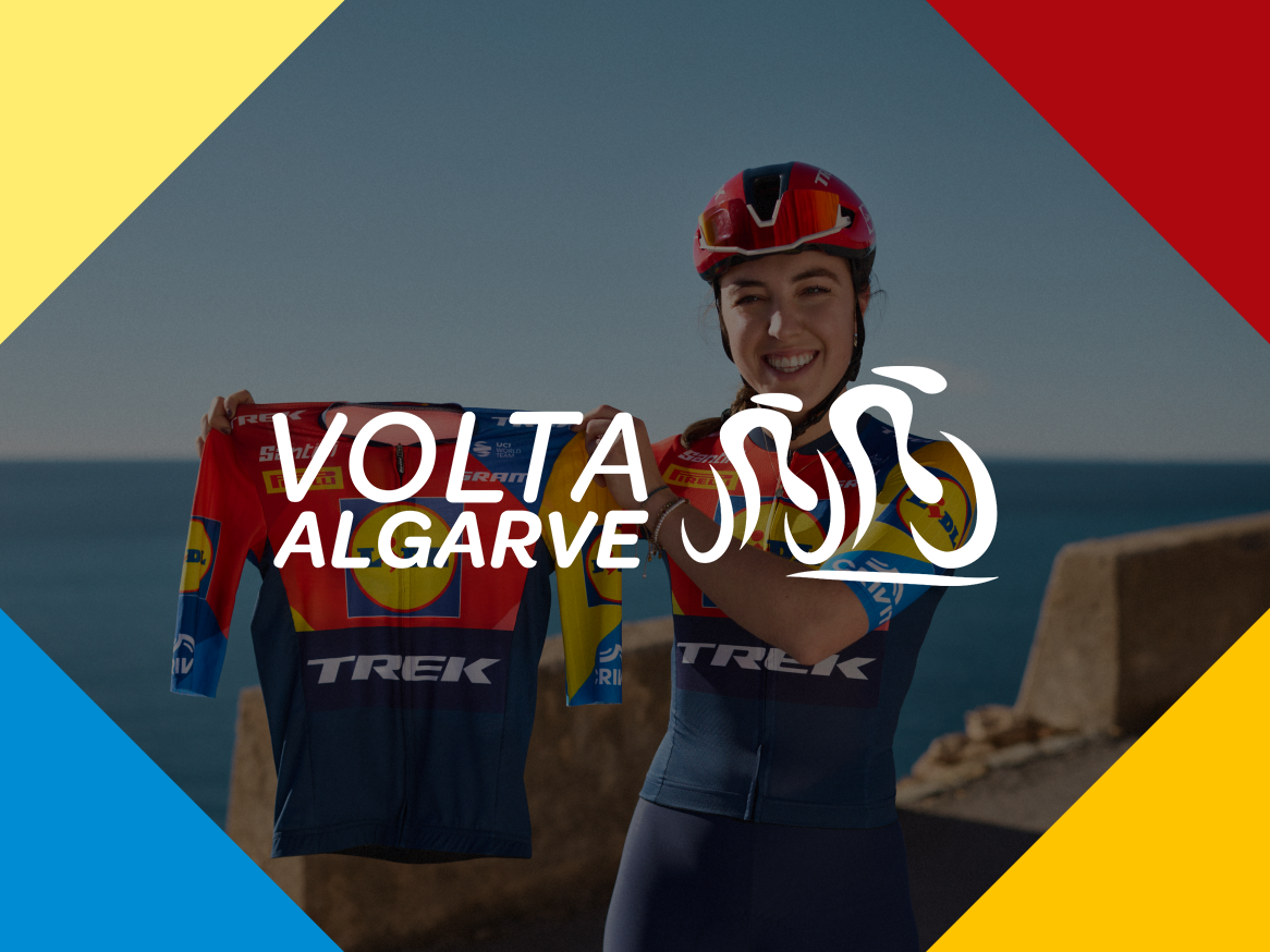 Ciclista feminina sorridente segura uma camisola de ciclismo, com o texto 'VOLTA ALGARVE' sobreposto.