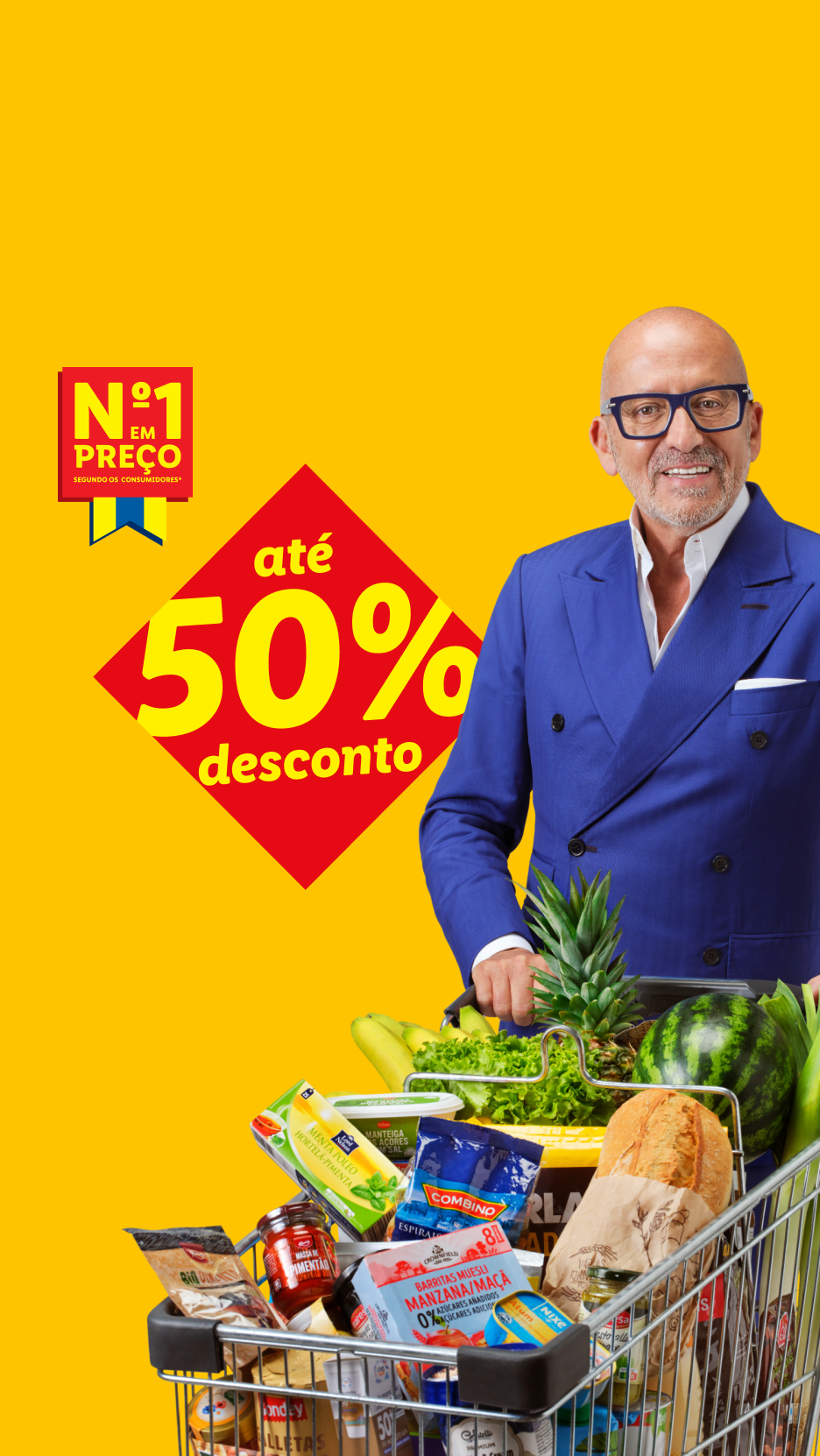 Homem sorridente com óculos, empurrando um carrinho de compras cheio de frutas, legumes e produtos de mercearia, com um selo de 'Nº1 em Preço' e 'até 50% desconto'.