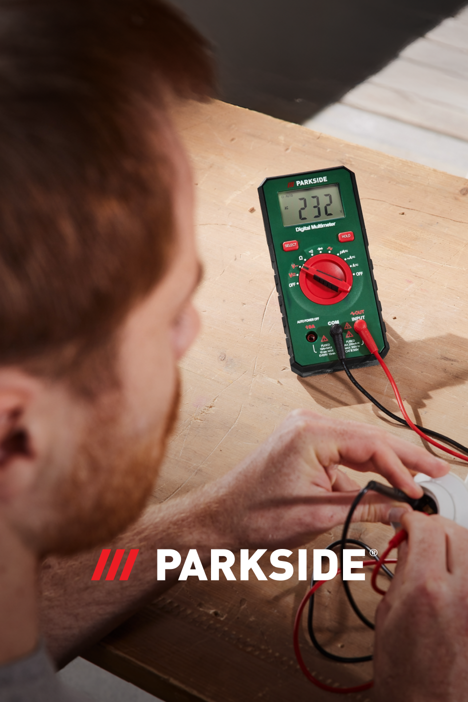 Um homem a usar um multímetro digital para medir a corrente elétrica.