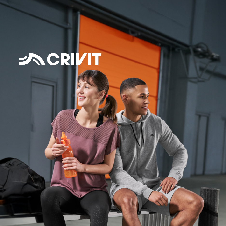 Homem e mulher em roupa desportiva sentados num banco, com garrafa de água e saco de ginásio.