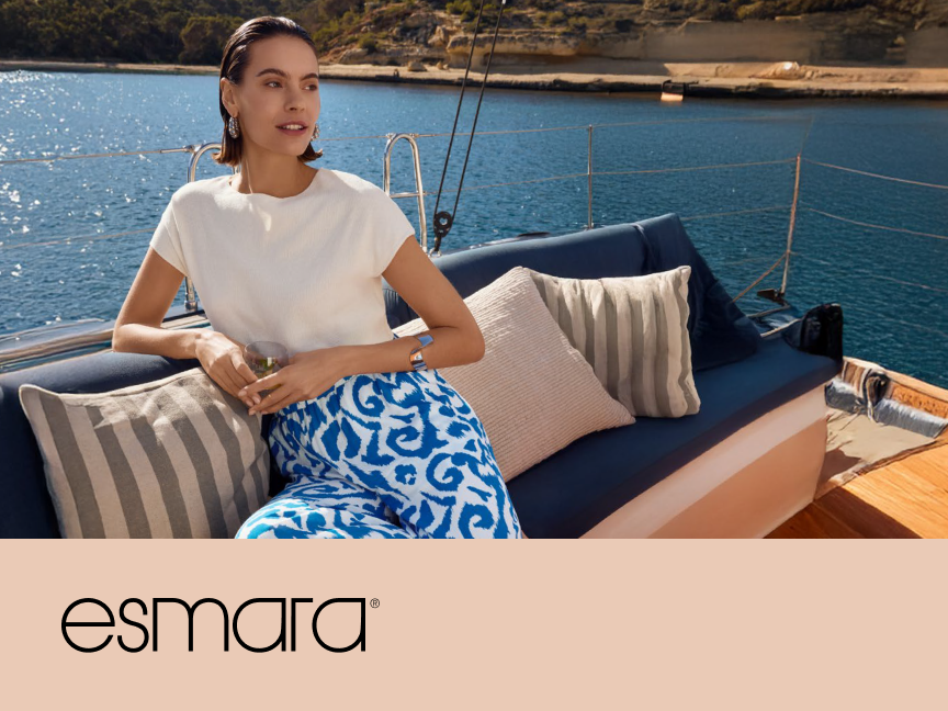 Esmara apresenta roupa de verão feminina: blusa branca e calça estampada, em um iate.