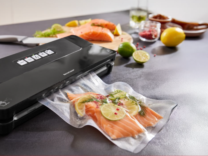 Seladora a vácuo da marca Sencor selando salmão com ervas e limões.