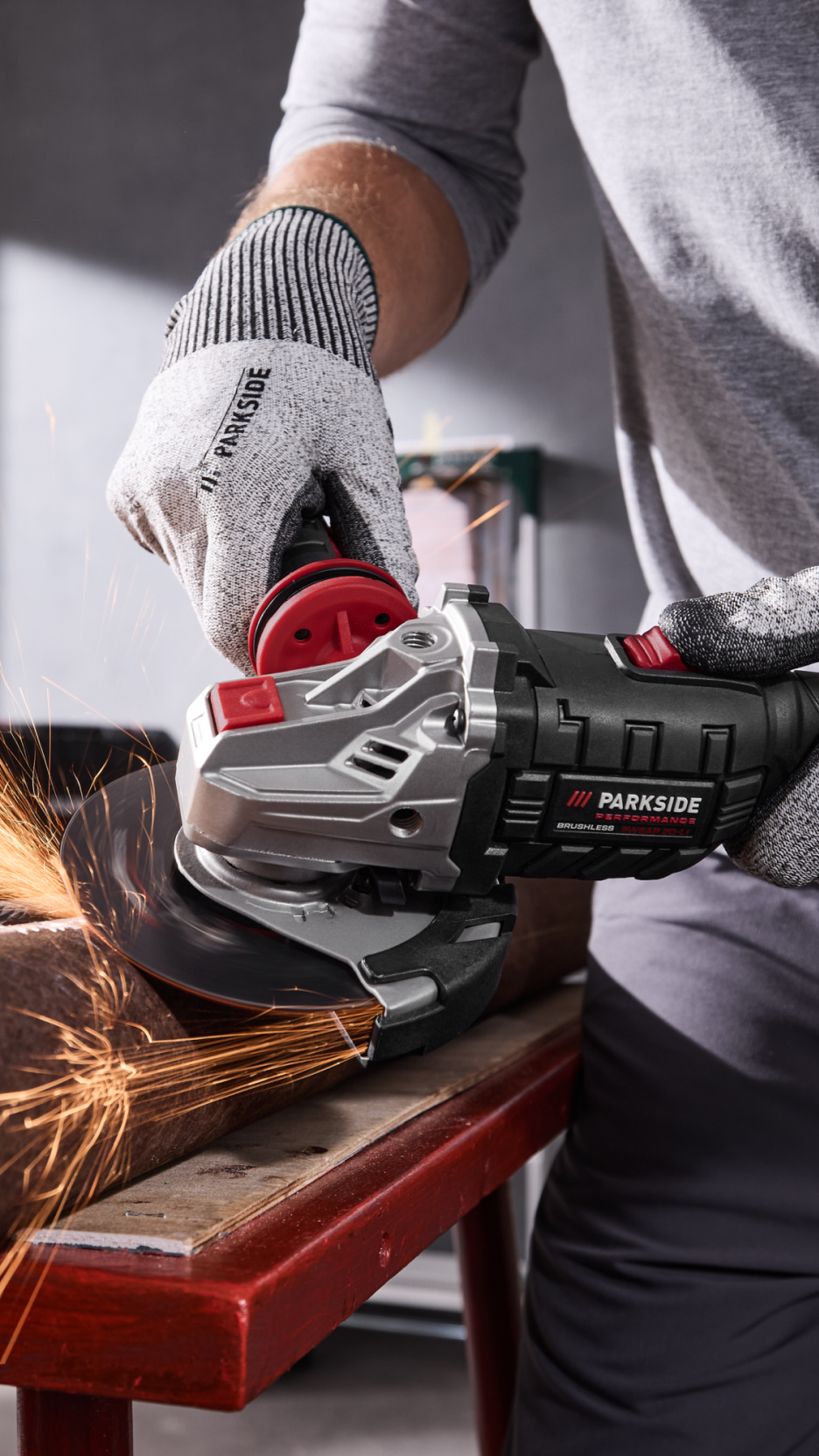 Homem a usar uma rebarbadora sem fios Parkside para cortar um tubo de metal, com faíscas a voar.