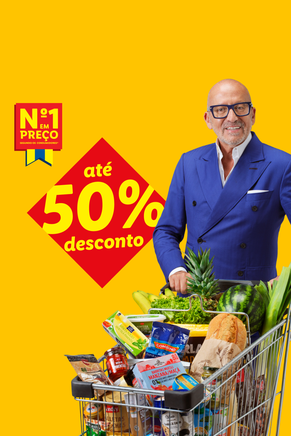 Homem sorridente com óculos empurrando um carrinho de compras cheio de frutas, vegetais e produtos embalados, com um banner de 'até 50% de desconto'.
