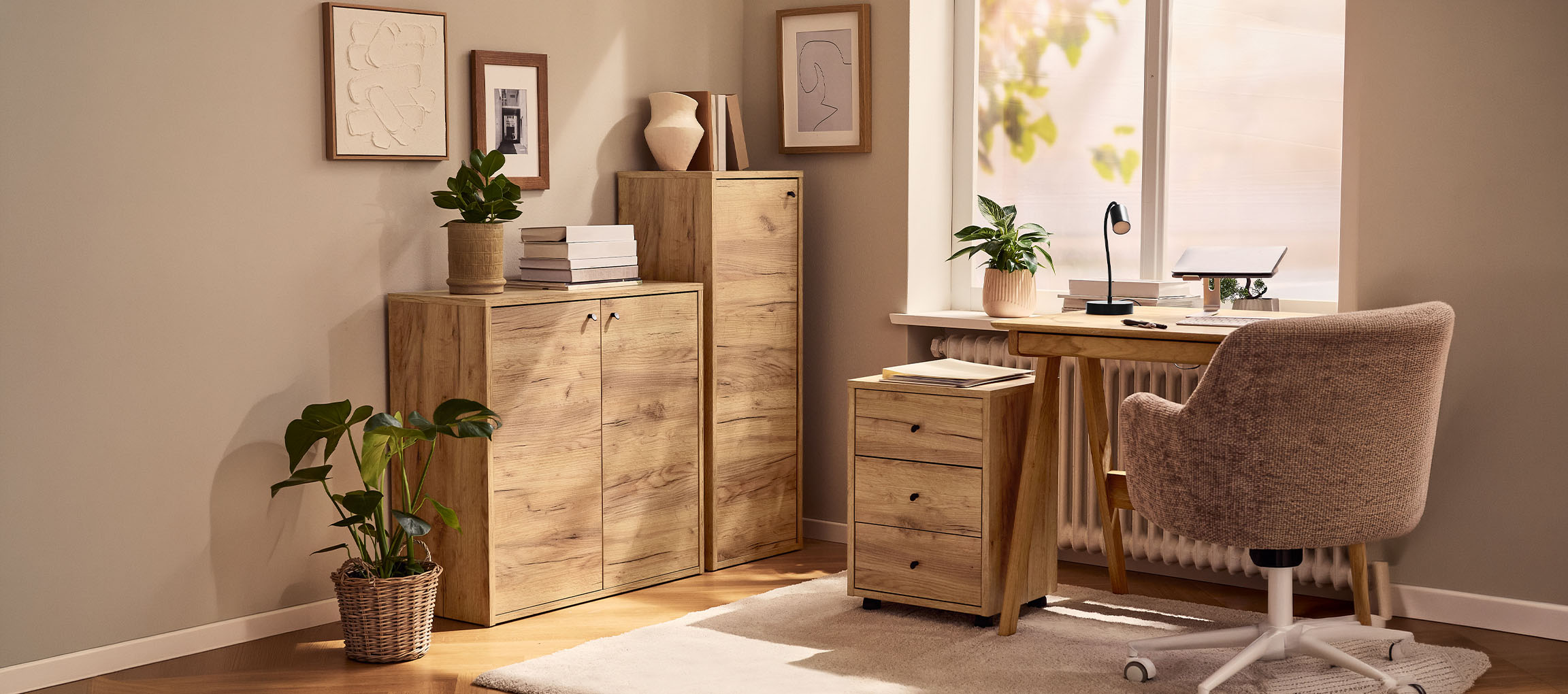 Escritório em casa com armários de madeira, secretária e cadeira, decorado com plantas e quadros.