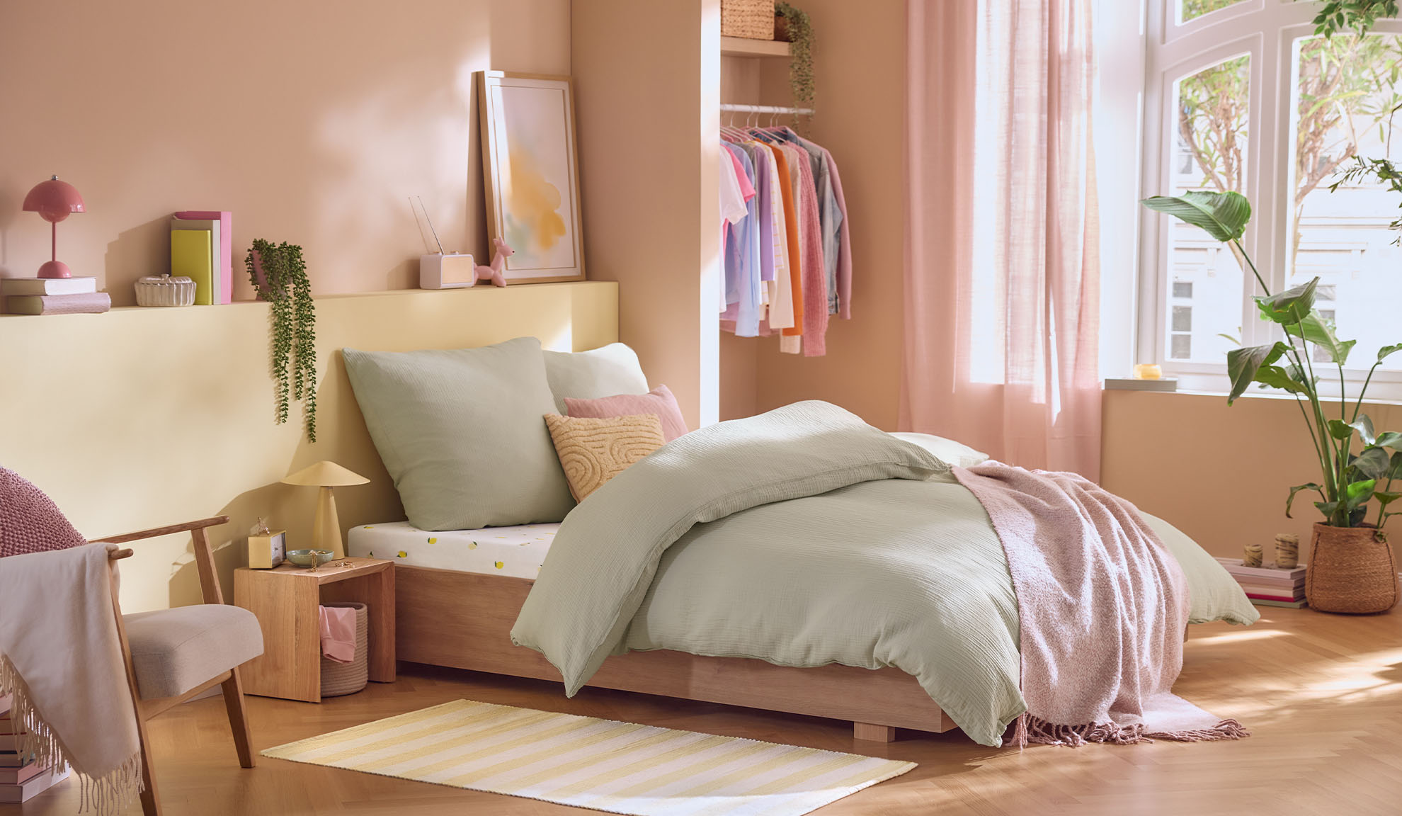 Quarto em tons pastel com cama, guarda-roupa e plantas, em estilo escandinavo.