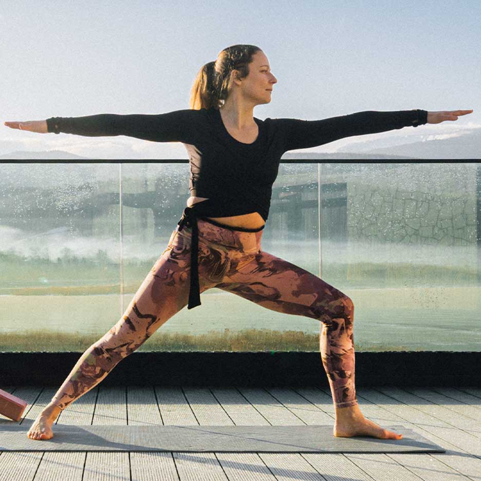 Mulher de leggings e top de ioga num terraço