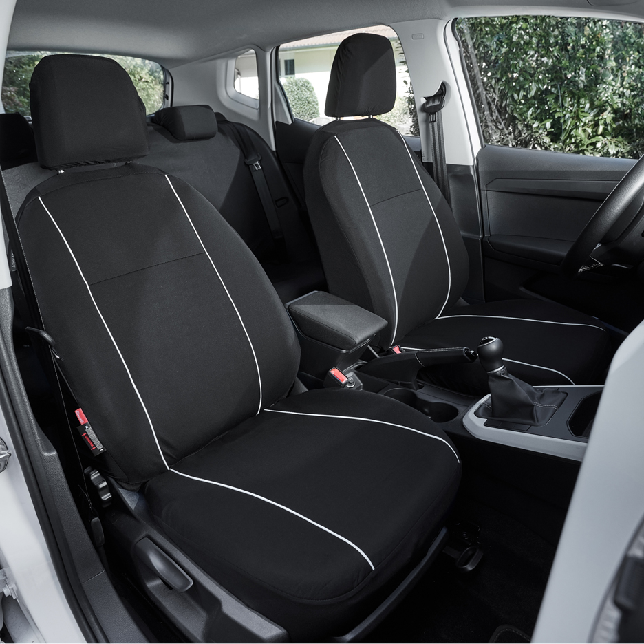 Capas de assento de carro pretas com detalhes brancos no interior de um carro.