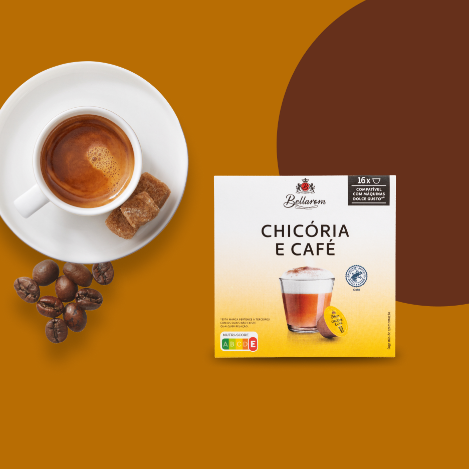 Uma chávena de café expresso com cubos de açúcar e grãos de café, ao lado de uma caixa de cápsulas de chicória e café da marca Bellarom.