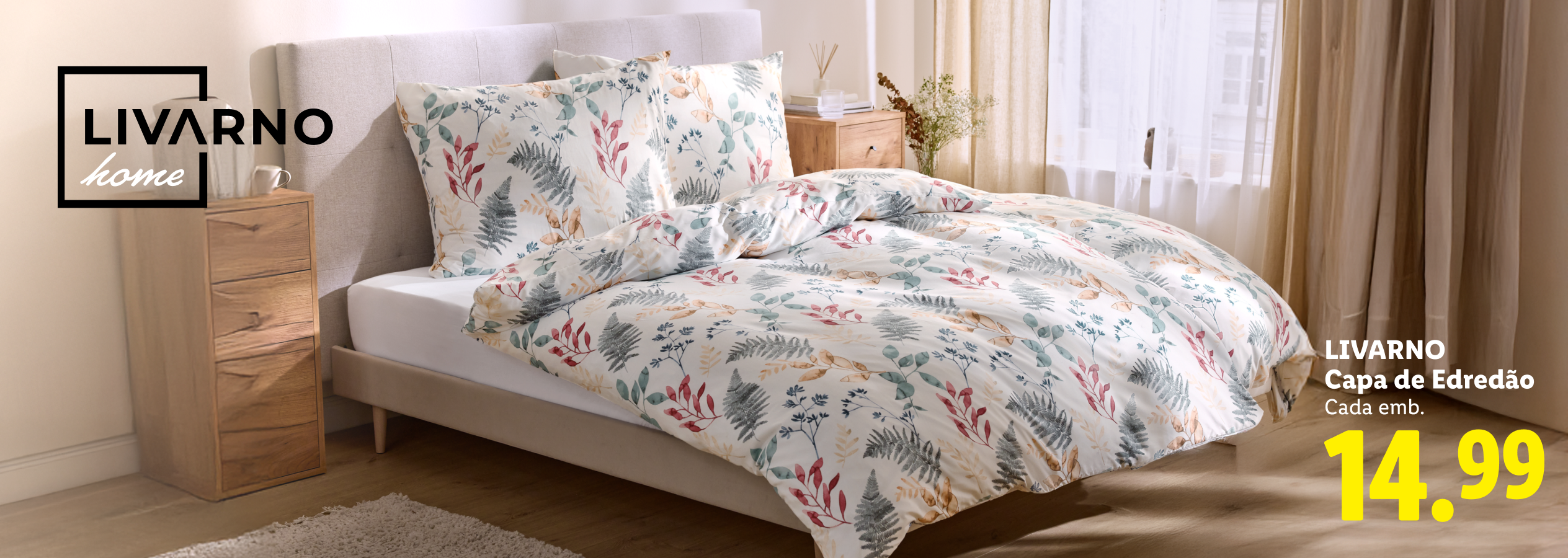 Capa de edredão com padrão floral e de folhas em tons de verde, vermelho e bege, sobre uma cama.