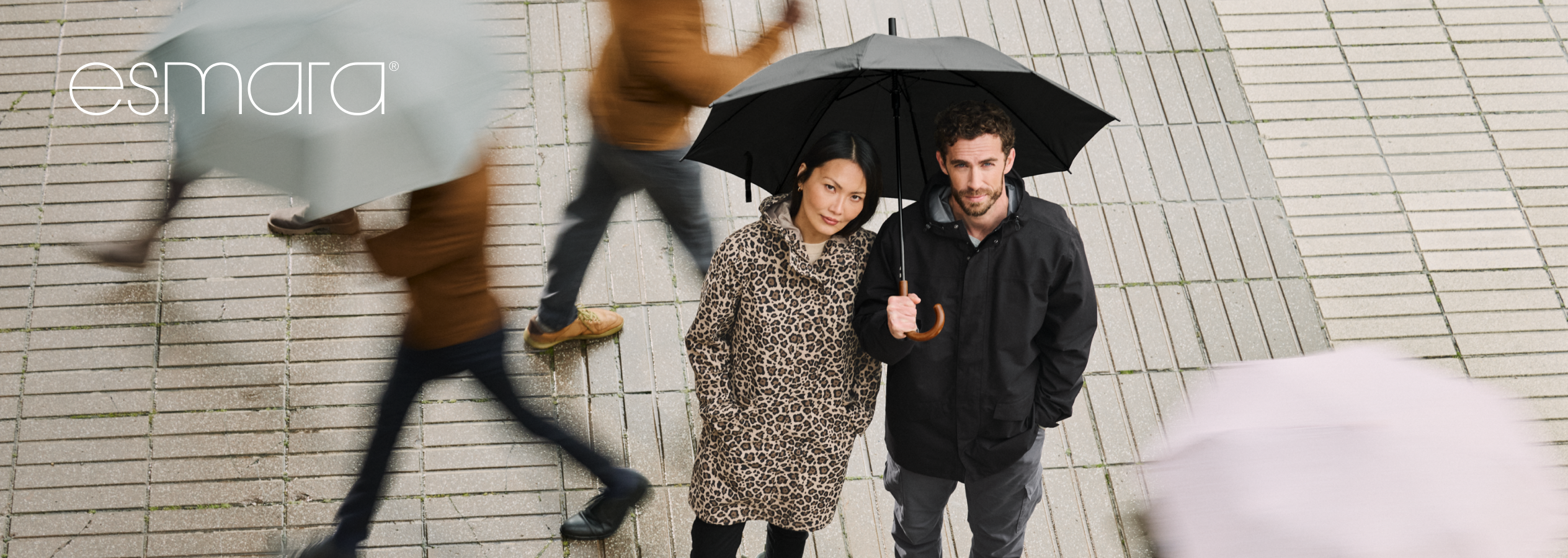 Casacos e guarda-chuvas Esmara para homem e mulher num dia chuvoso.