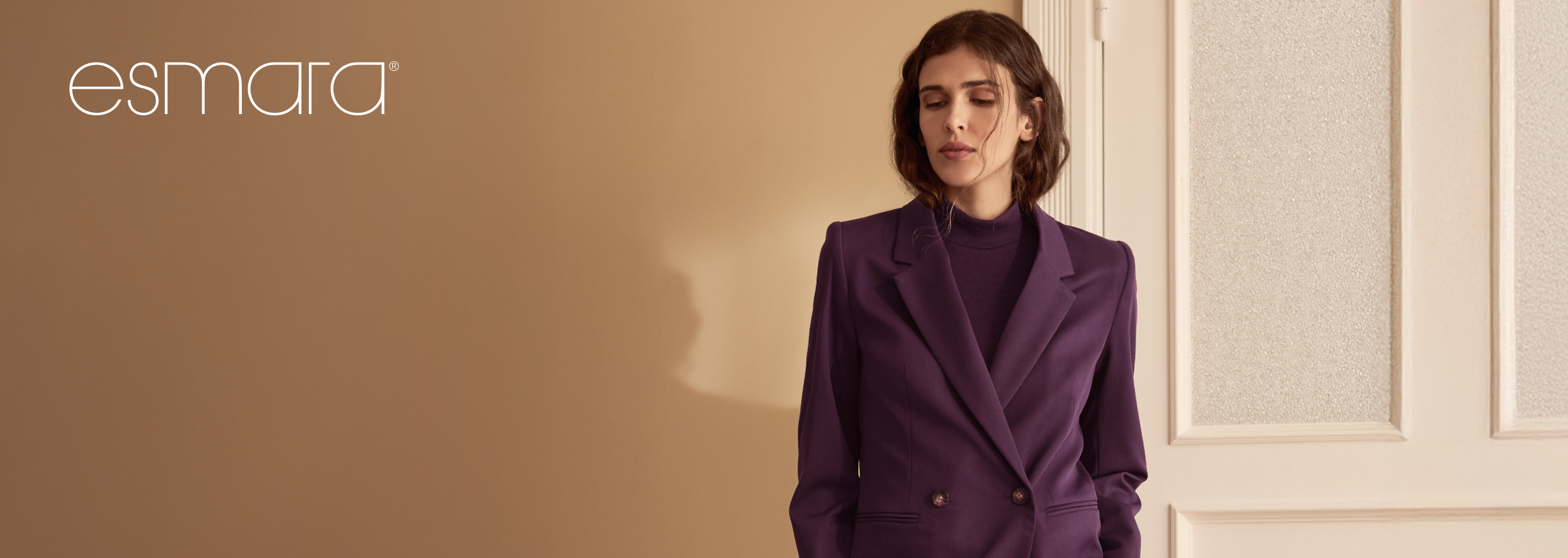 Mulher com blazer e camisola de gola alta roxos da Esmara.