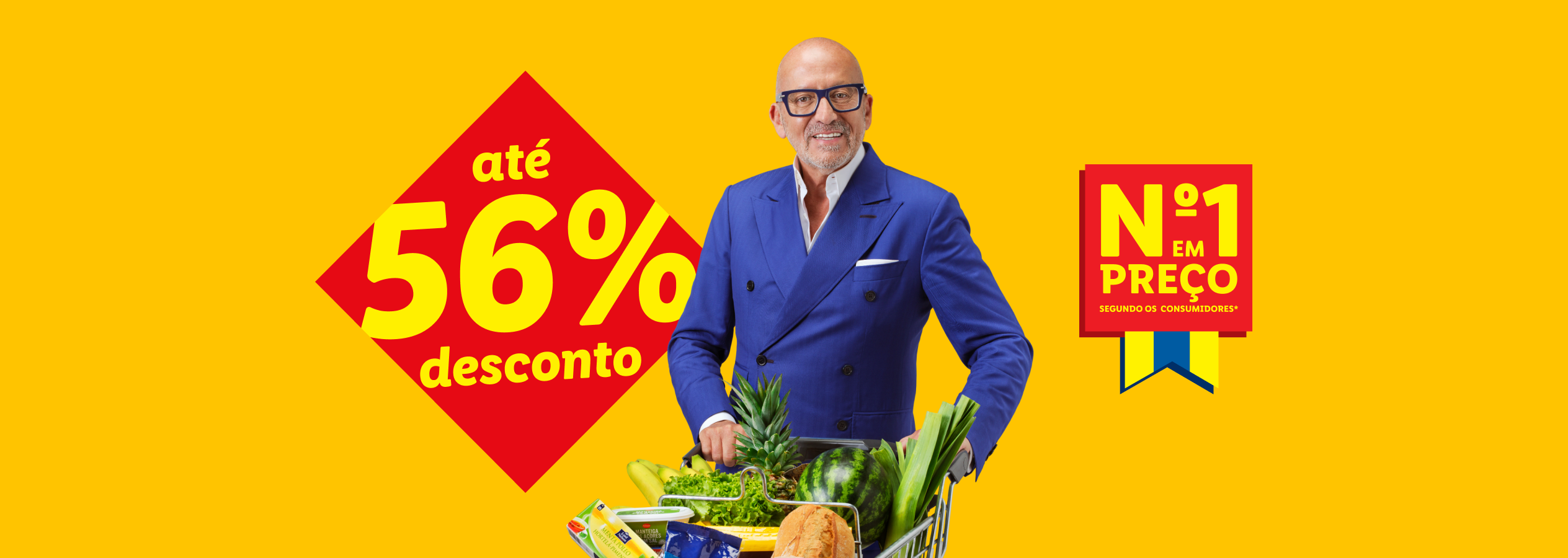 Homem sorridente com óculos, empurrando um carrinho de compras cheio de frutas e legumes, com um desconto de até 56% e o selo 'Nº1 em Preço'.