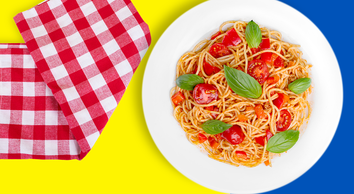 Spaghetti com molho de tomate e manjericão, guardanapo vermelho e branco xadrez.