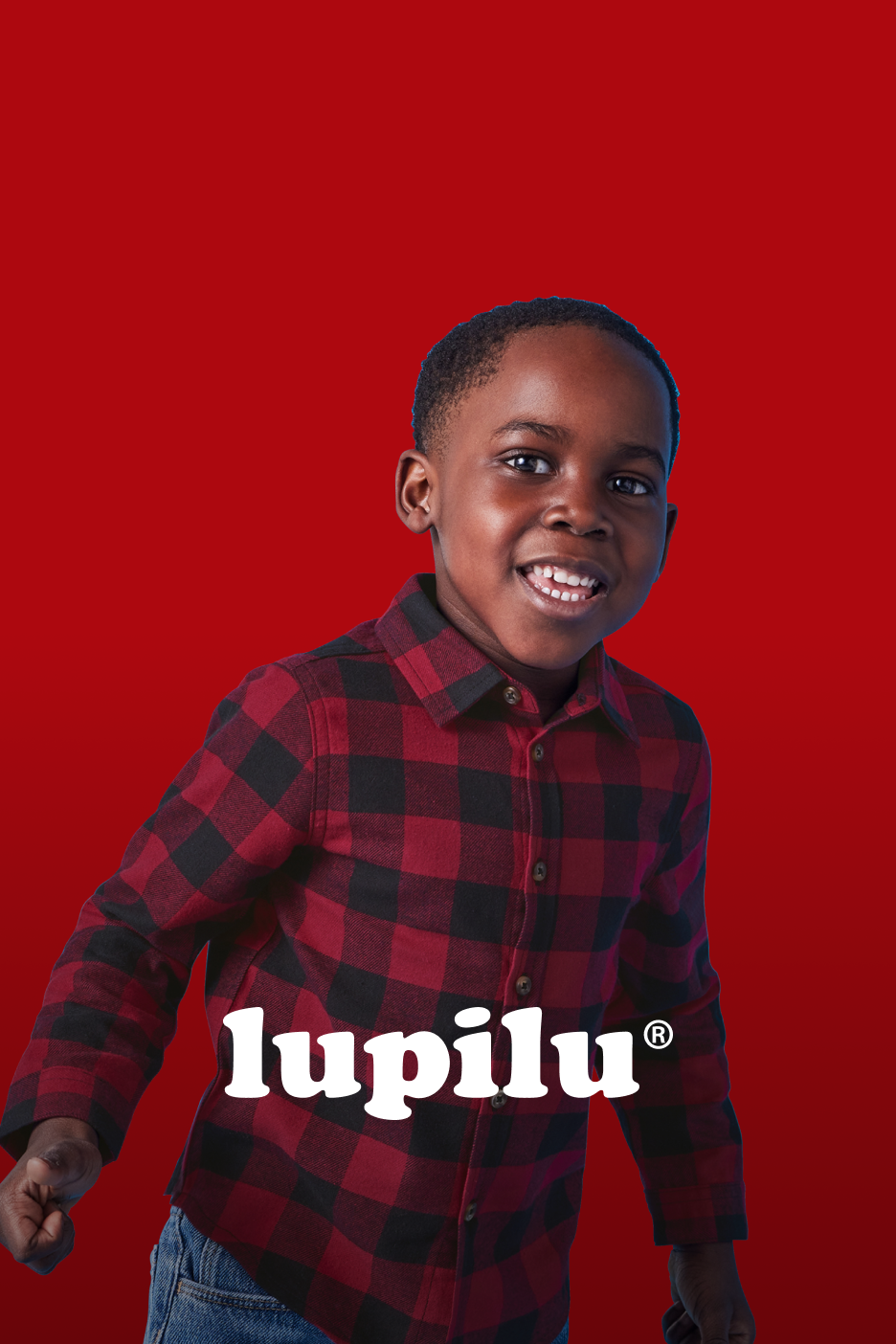 Menino sorridente com camisa xadrez vermelha e preta, com o logótipo Lupilu.