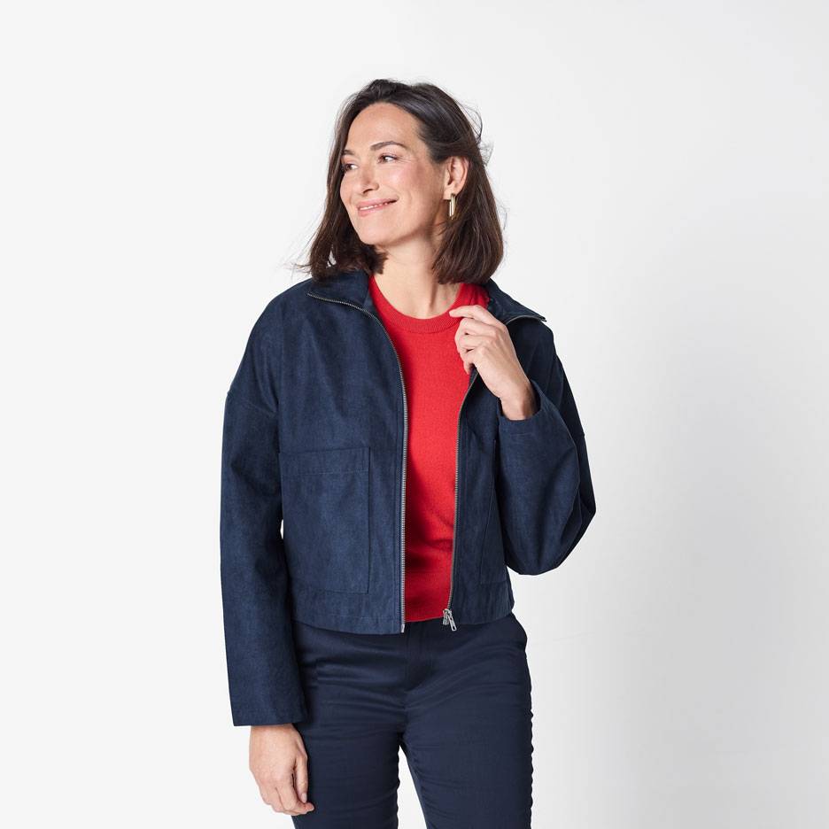 Mulher com casaco bomber azul escuro e camisola vermelha
